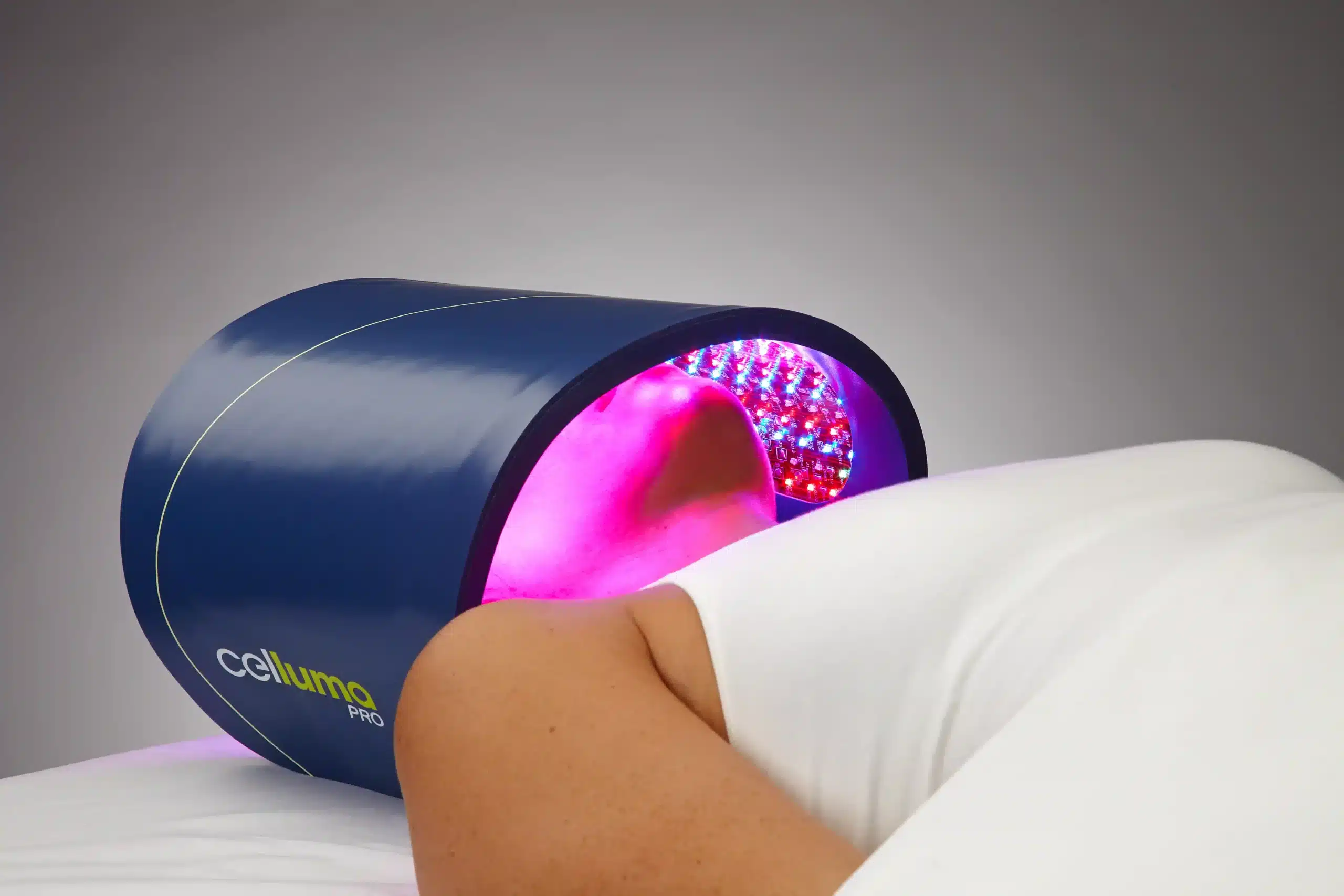 Celluma PRO red light therapy device emitting pink therapeutic light over face for anti-aging treatment